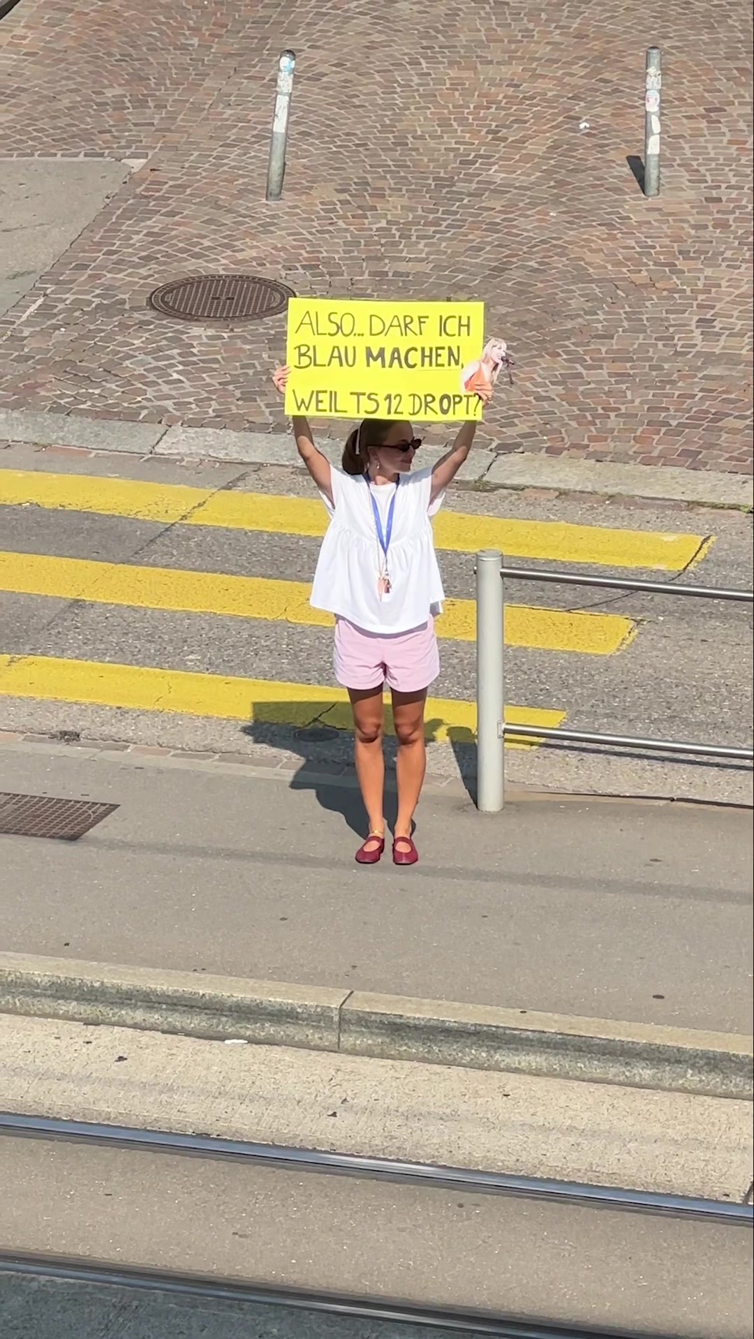 Eine Frau hält ein Schild am Strassenrand.