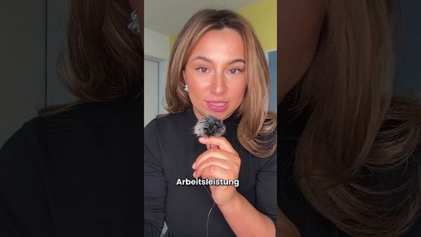 Eine Frau hält ein Mikrofon und spricht, im Bild ist das deutsche Wort „Arbeitsleistung“ eingeblendet.