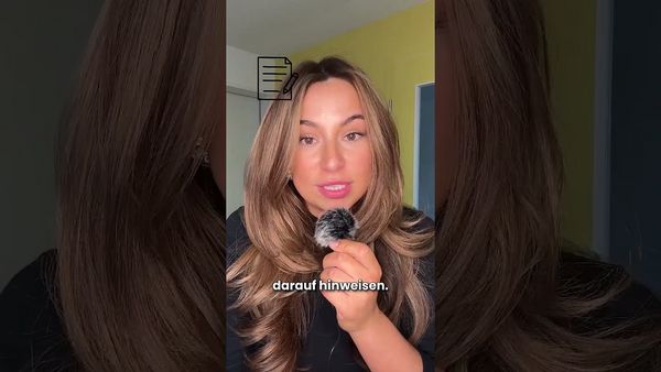 Eine Frau mit langen blonden Haaren hält ein kleines flauschiges Objekt und blickt in die Kamera; eingeblendeter Text „darauf hinweisen.“.